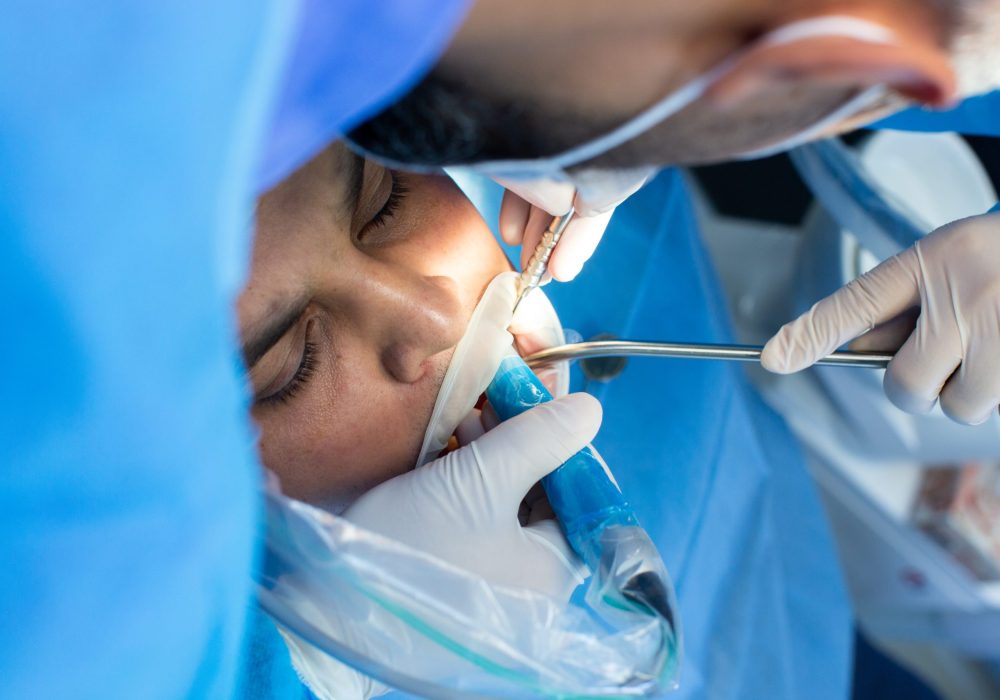 dentist and assistant with tool makes some manipulations in the patient's mouth